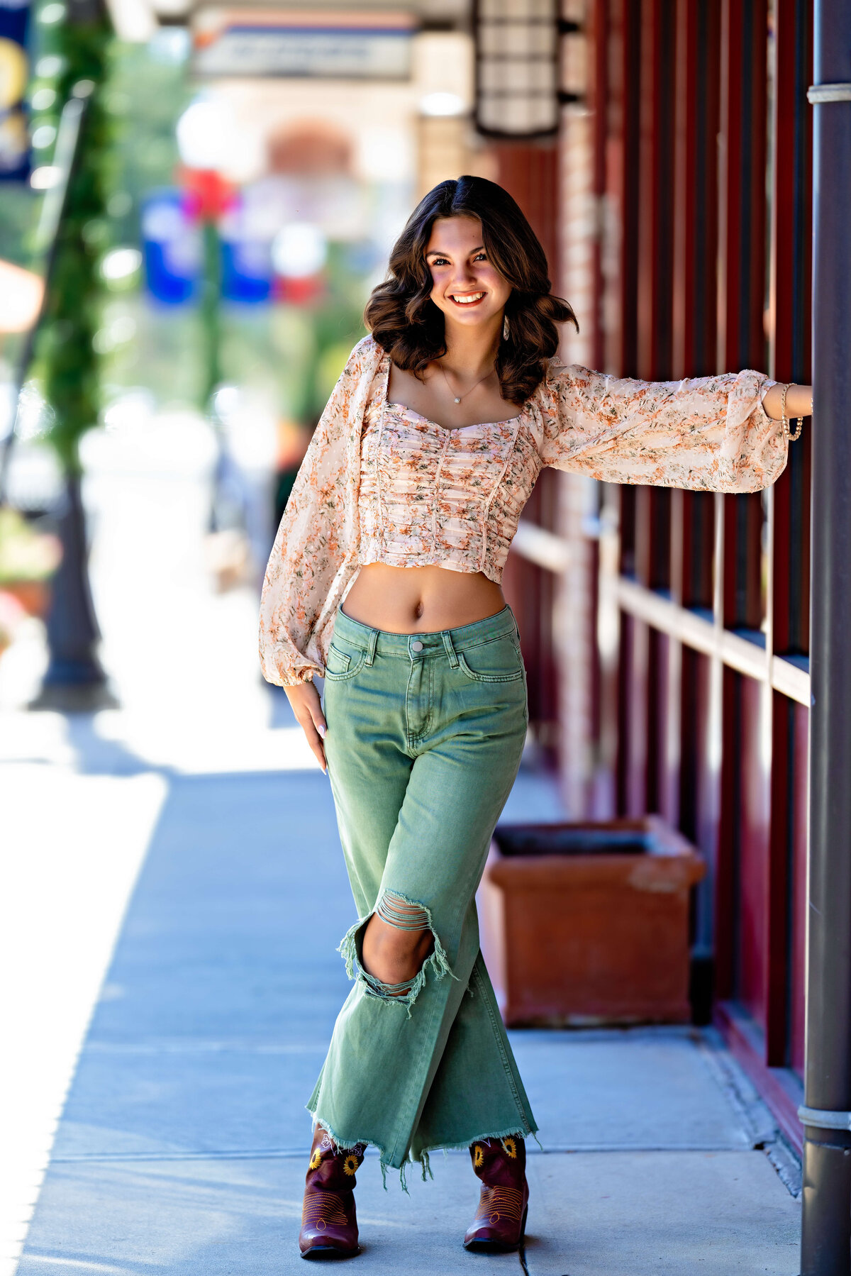 Senior girl in wide-leg pants posing confidently on sidewalk in Winter Garden