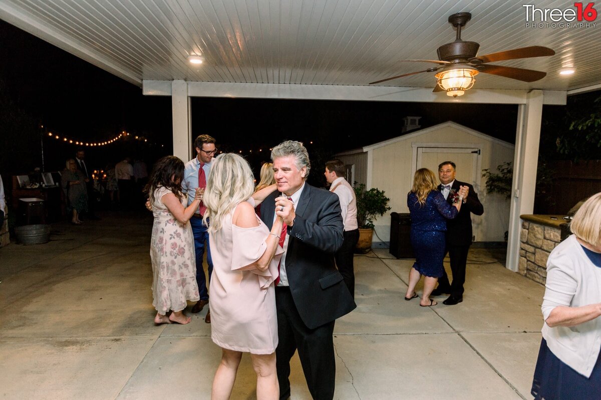 Wedding guests share the dancefloor during a backyard micro wedding
