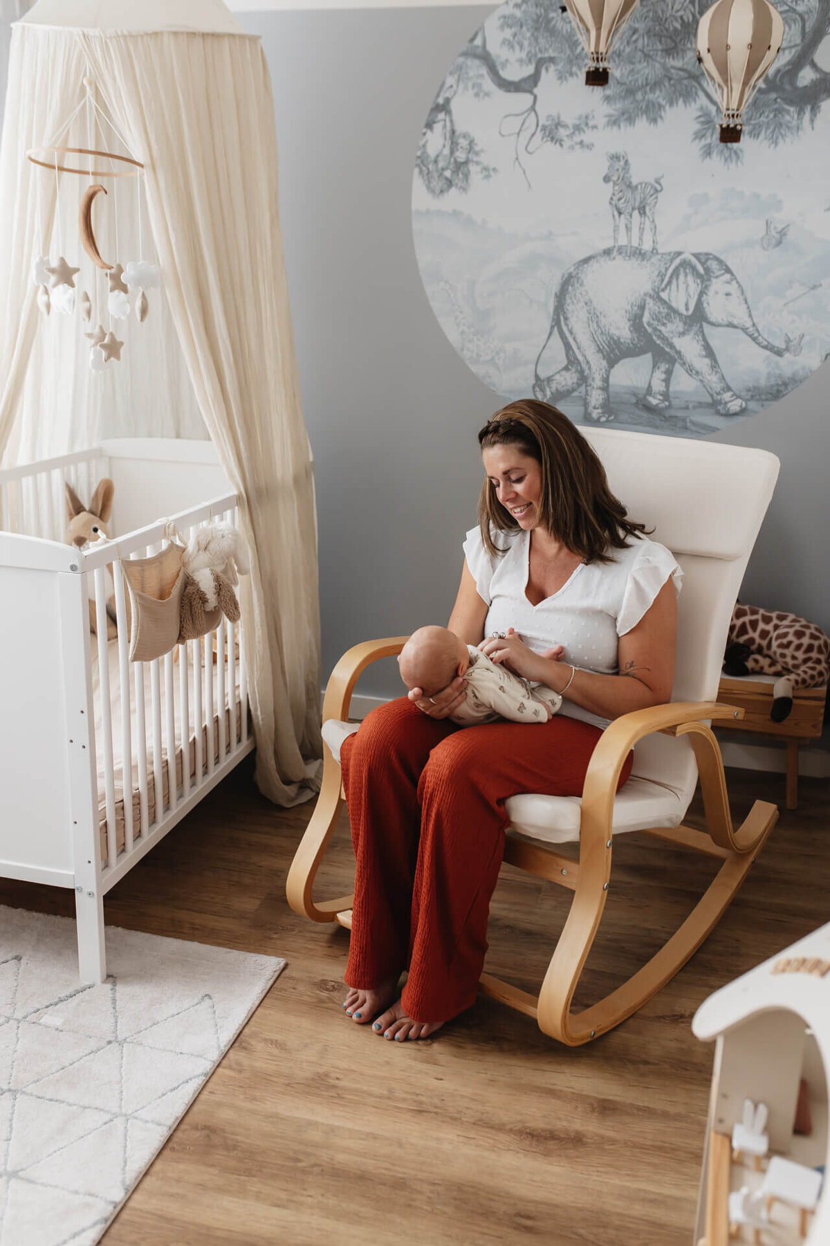 Kraamreportage mama zit met baby in de schommelstoel