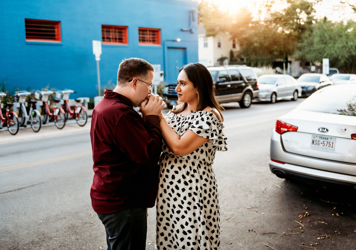 Couples Photography, man kisses woman's hands affectionately in the street