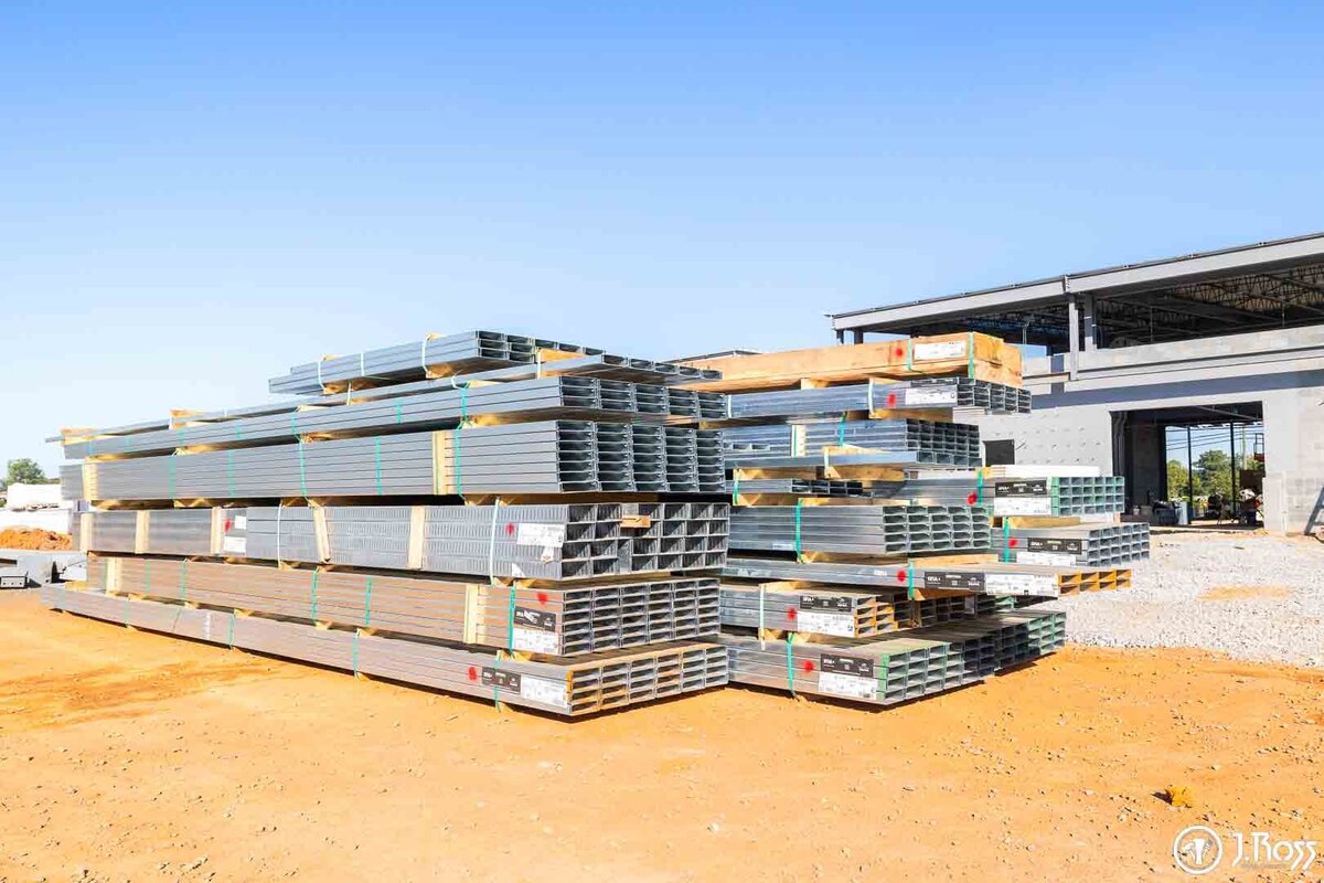 A large stack of new metal drywall studs and tracks from J.Ross Painting & Drywall on the TCAT building site, ready for commercial framing in Greeneville, TN.