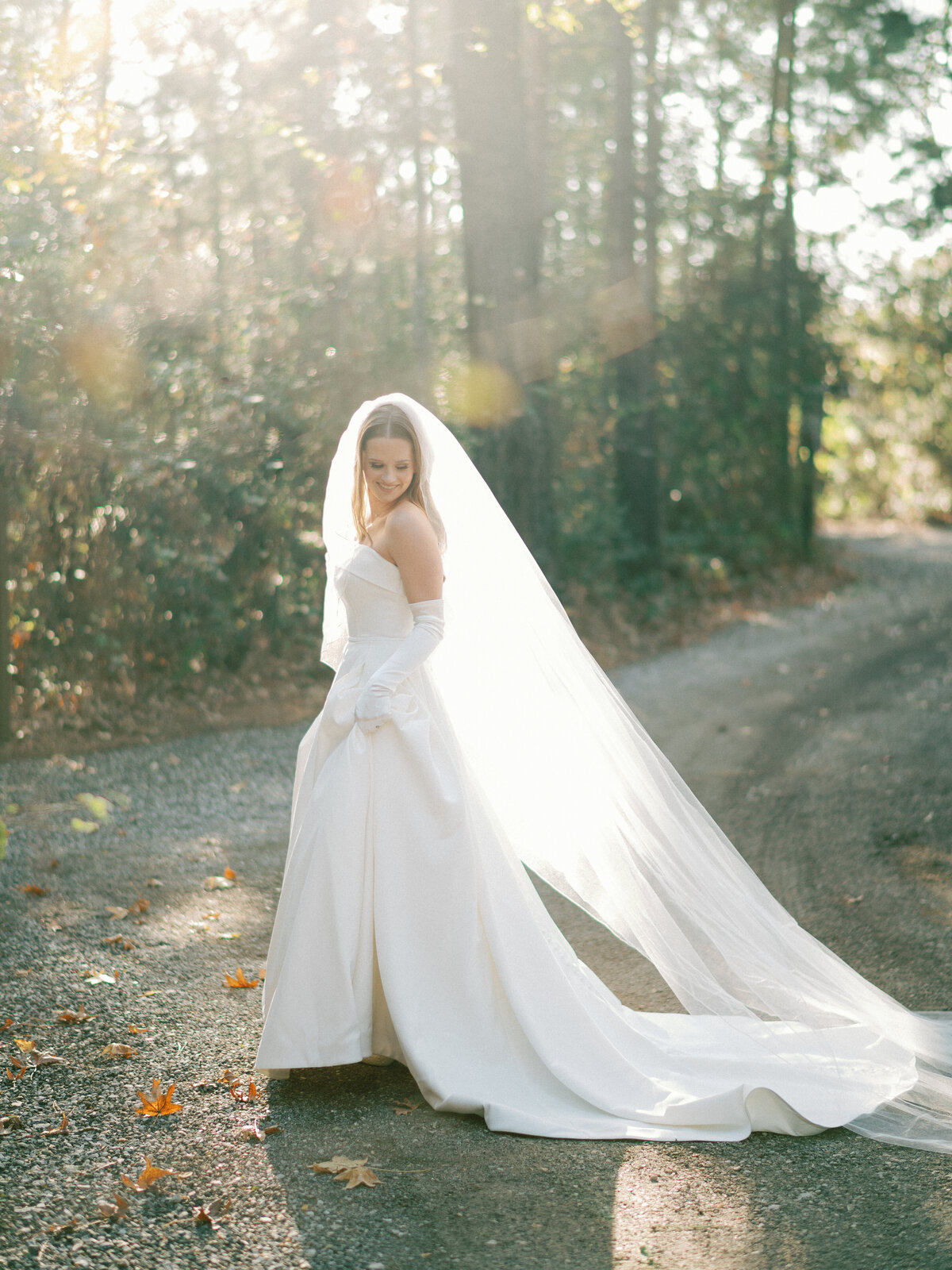 Bride with gloves in strapless modern dress and veil candid
