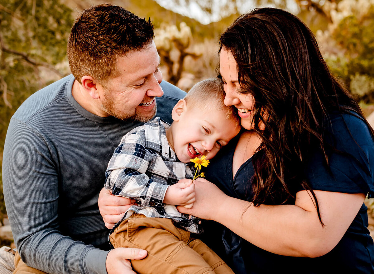 mom and dad hugging son for family photographer in Arizona