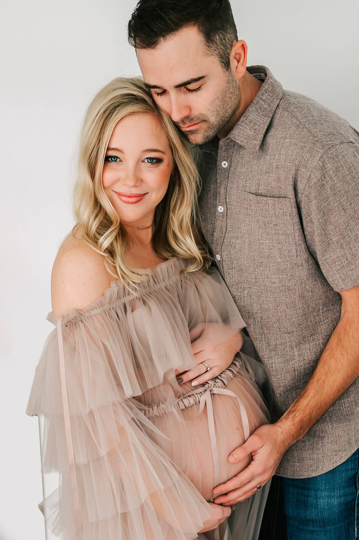 Springfield MO maternity photographer capturespregnant couple cuddling in tulle dress