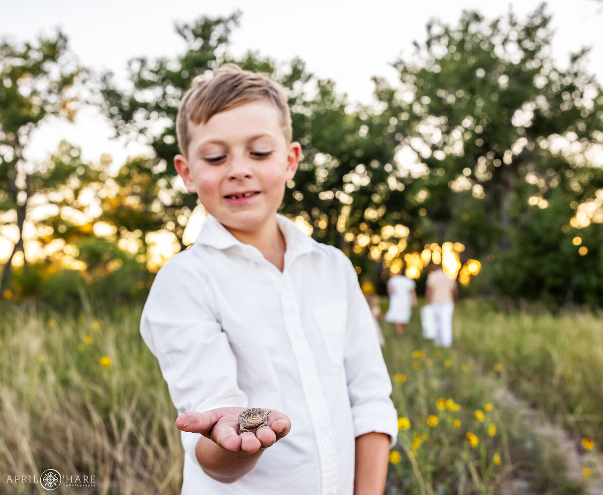 Young Boy Holds Toad in Hand at Family Photoshoot in Parker CO