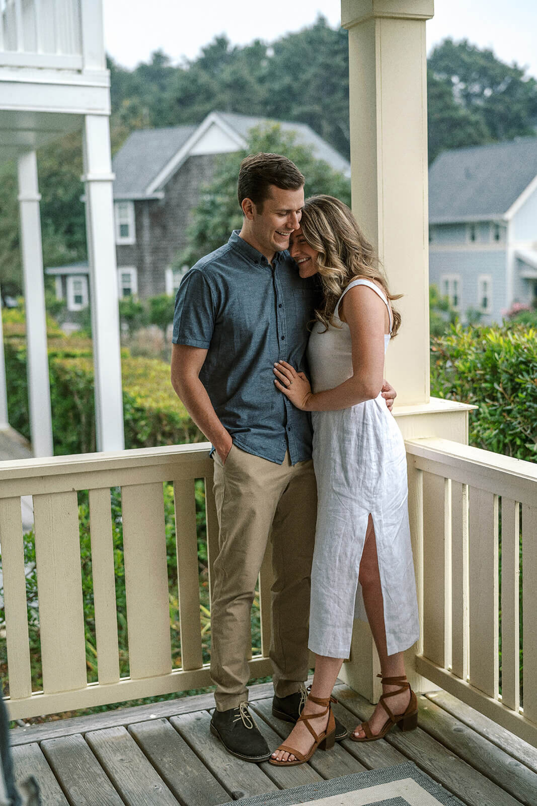 A couple embracing on a front porch. 