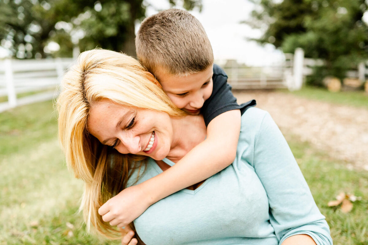 Son with arms around mother in a candid embrace at Sunset Farm.