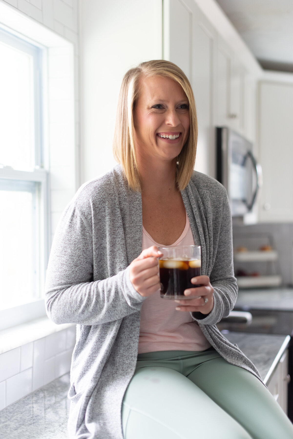 Branding photo of mompreneur in the kitchen holding a iced coffee