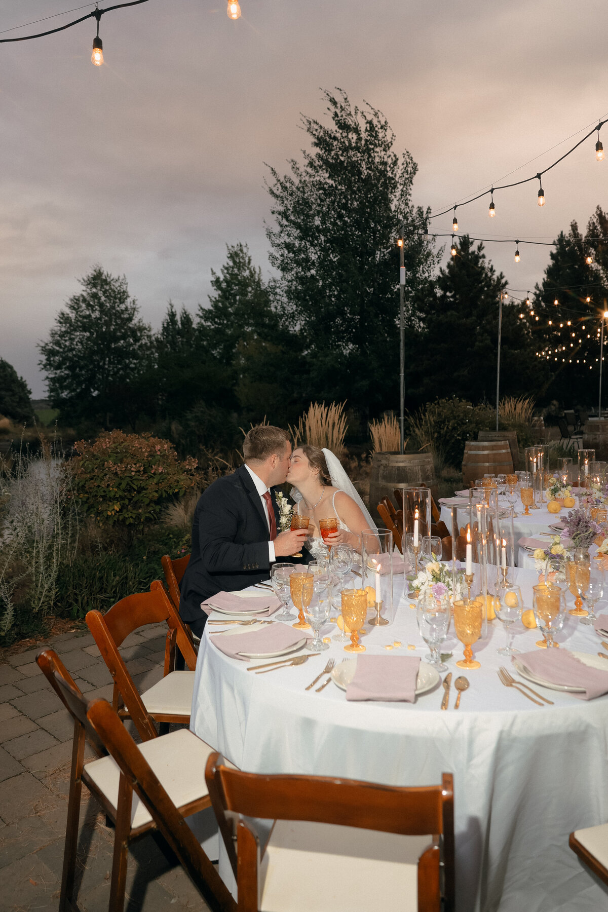 Golden Hour Reception Kiss Under String Lights | Intimate Outdoor Oregon Wedding