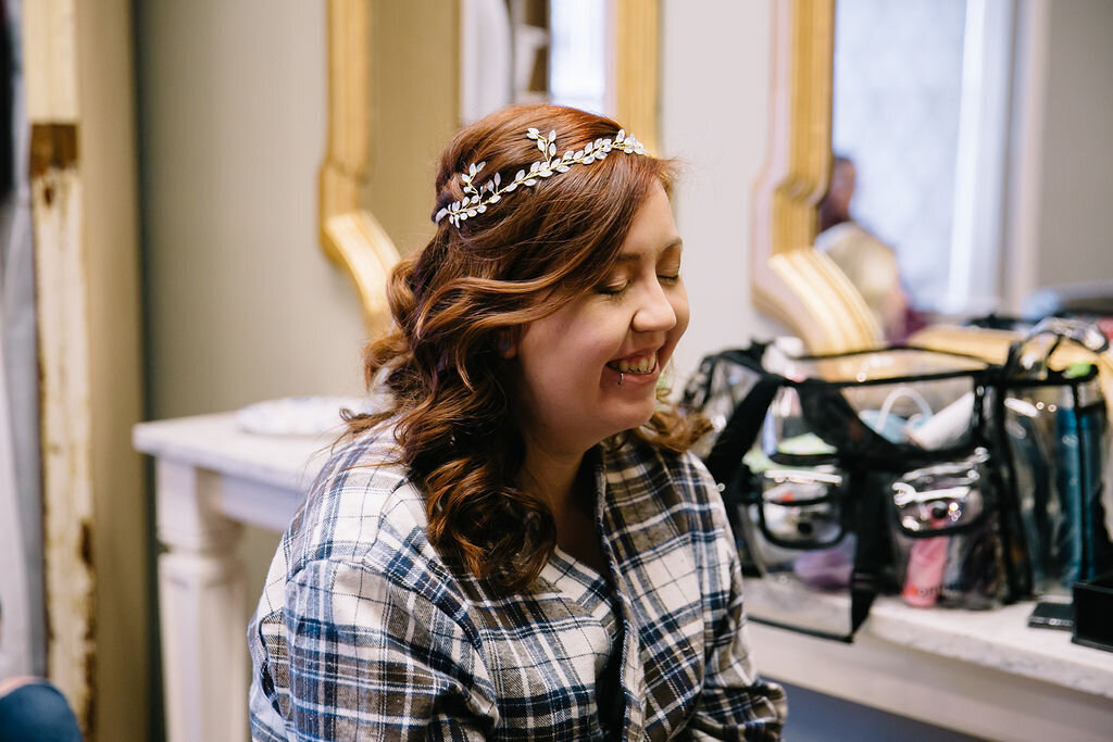A bride gets ready for her wedding in the Norton Building Bridal Suite. Her hair is curled and she is wearing a dainty tiara with a plaid robe.A bride gets ready for her wedding in the Norton Building Bridal Suite. Her hair is curled and she is wearing a dainty tiara with a plaid robe.