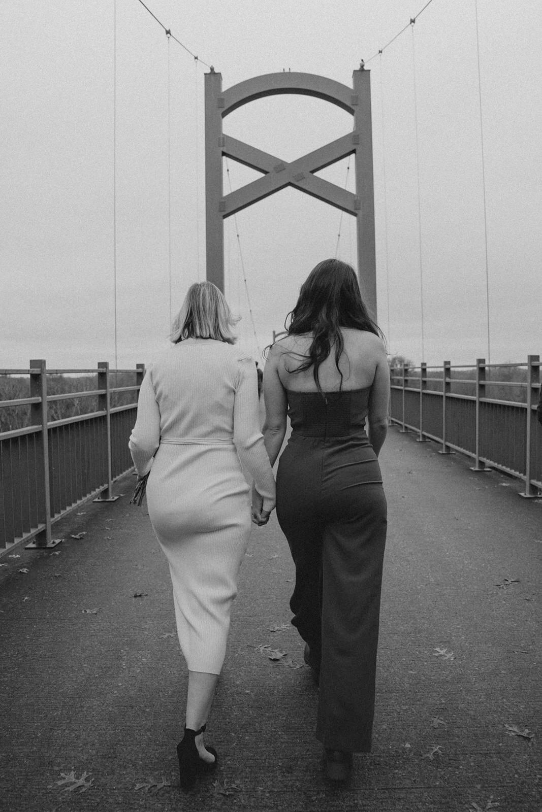 New wives hold hands and walk across a Nashville Tennessee bridge