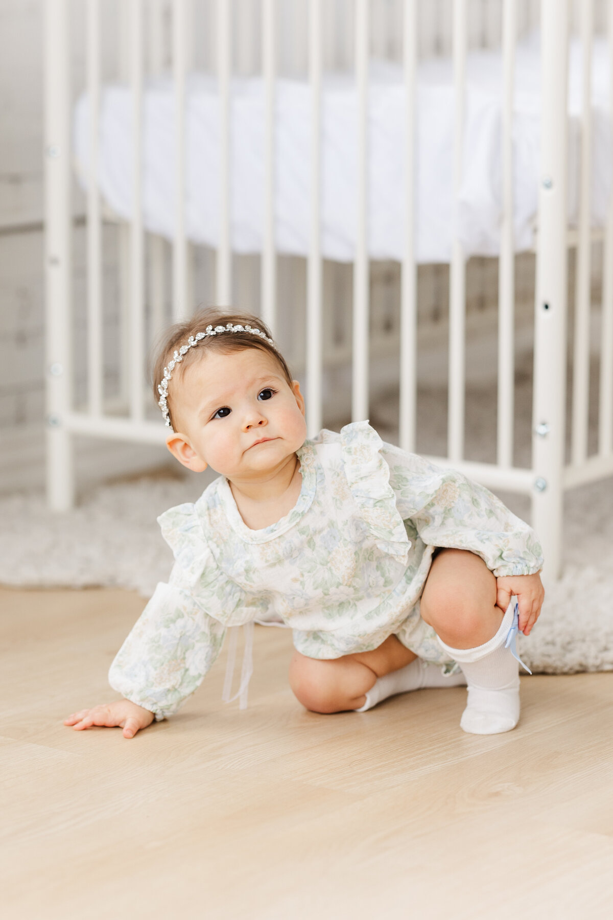 1-year-old-baby-girl-in-floral-romper-and-knee-high-socks