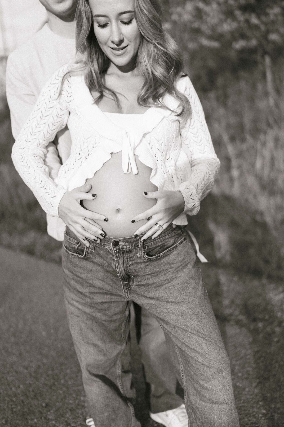 man holds pregnant wife's belly in autumn in knoxville tennessee