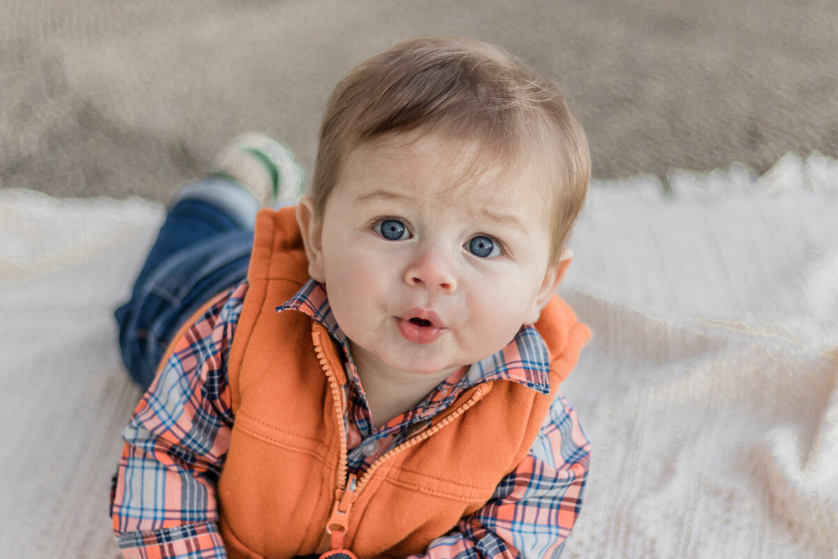 baby laying on his stomach looking at the camera