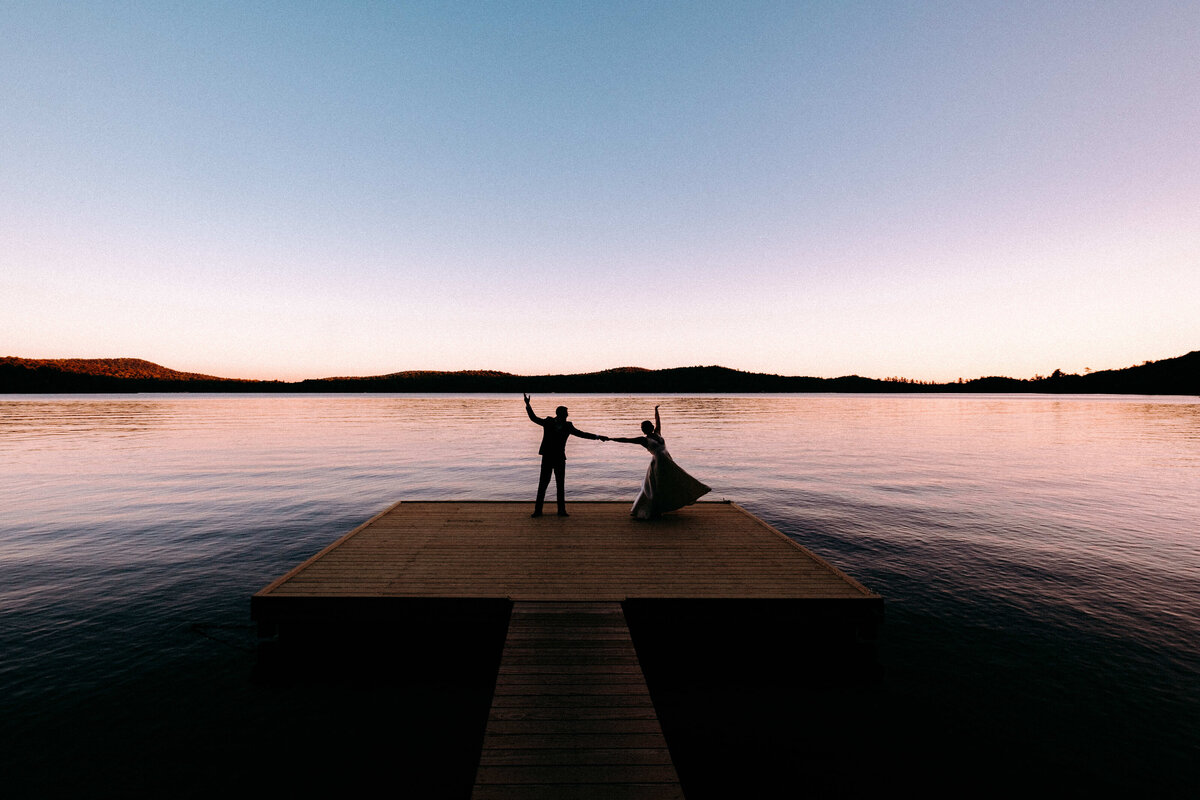 Silhouetted Couple dancing on a dock in Big Moose Lake, NY.