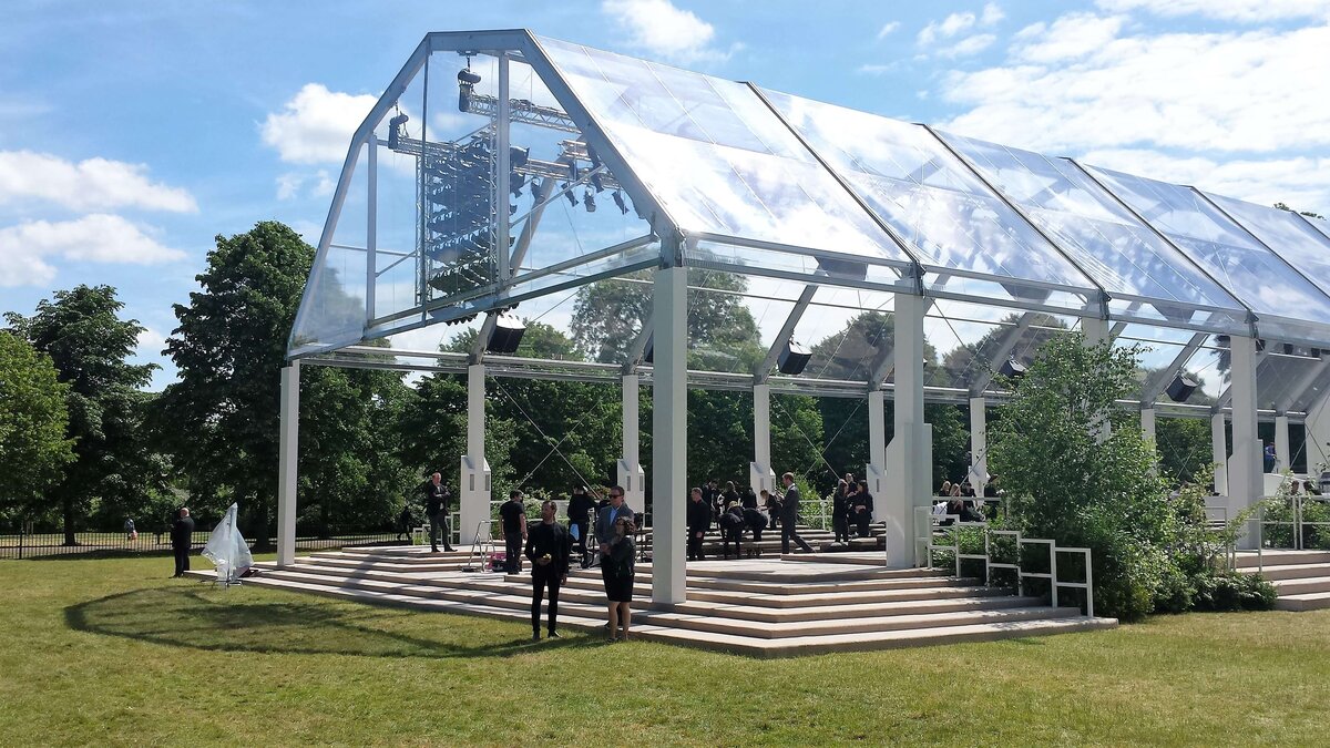 A large frame marquee with a long walkway and trees outside of the front
