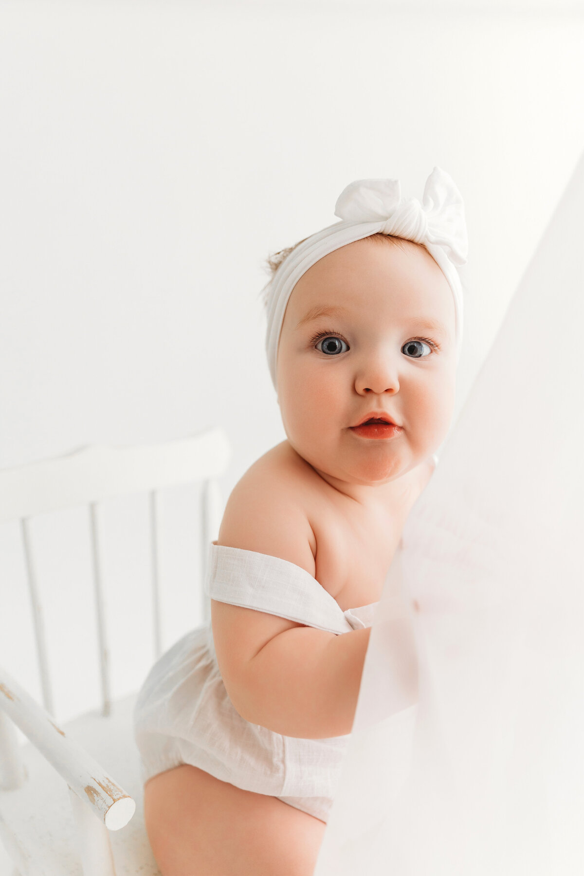 Baby girl with white bow in Phoenix milestone session