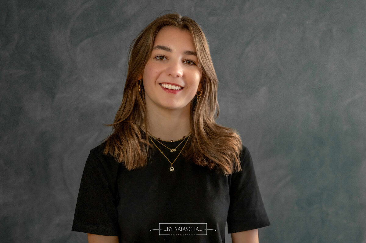 Portret foto van medewerker Haarstudio Heesch voor een blauwe wand