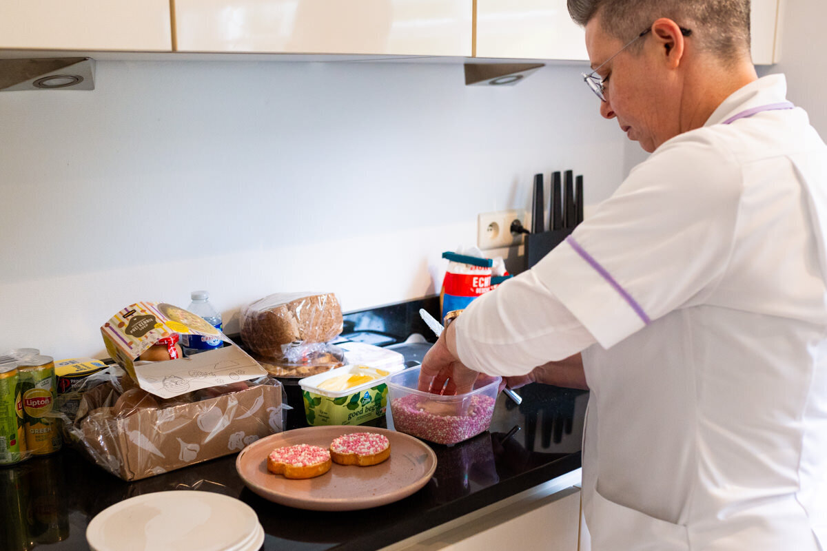 kraamverzorgster maakt beschuit met muisjes