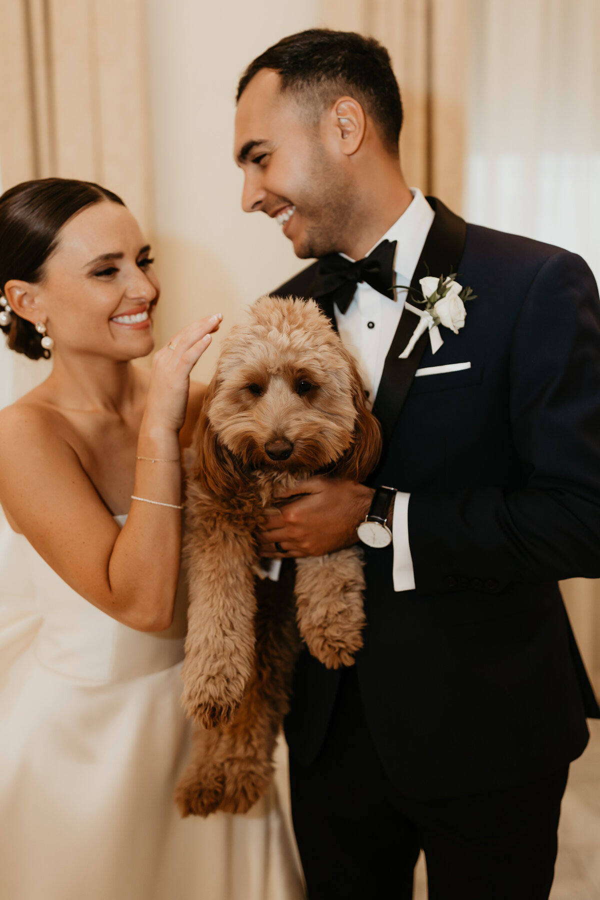 Bride and Groom Holding their Golden Doodle Puppy