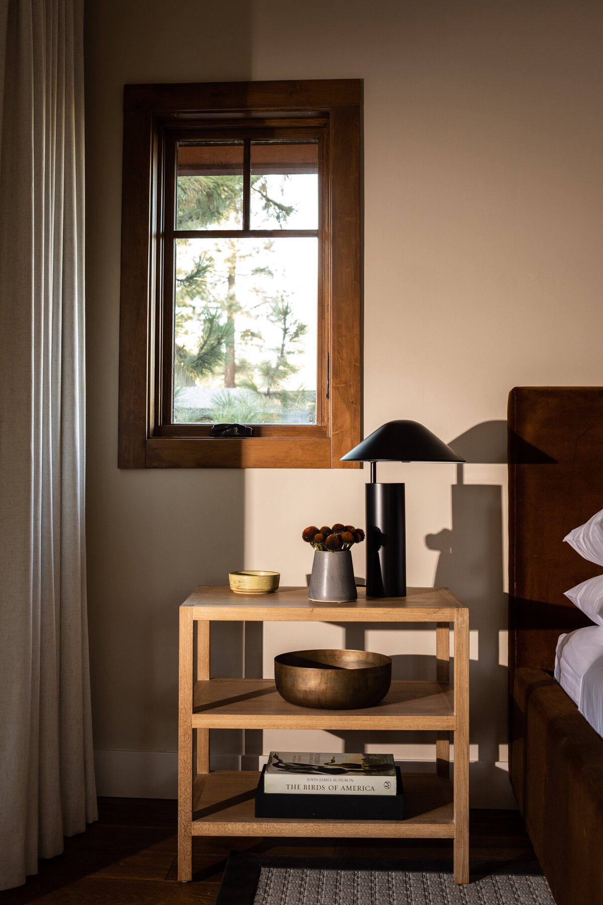 Stylish bedside table with modern decor and warm lighting, featured in interior photography