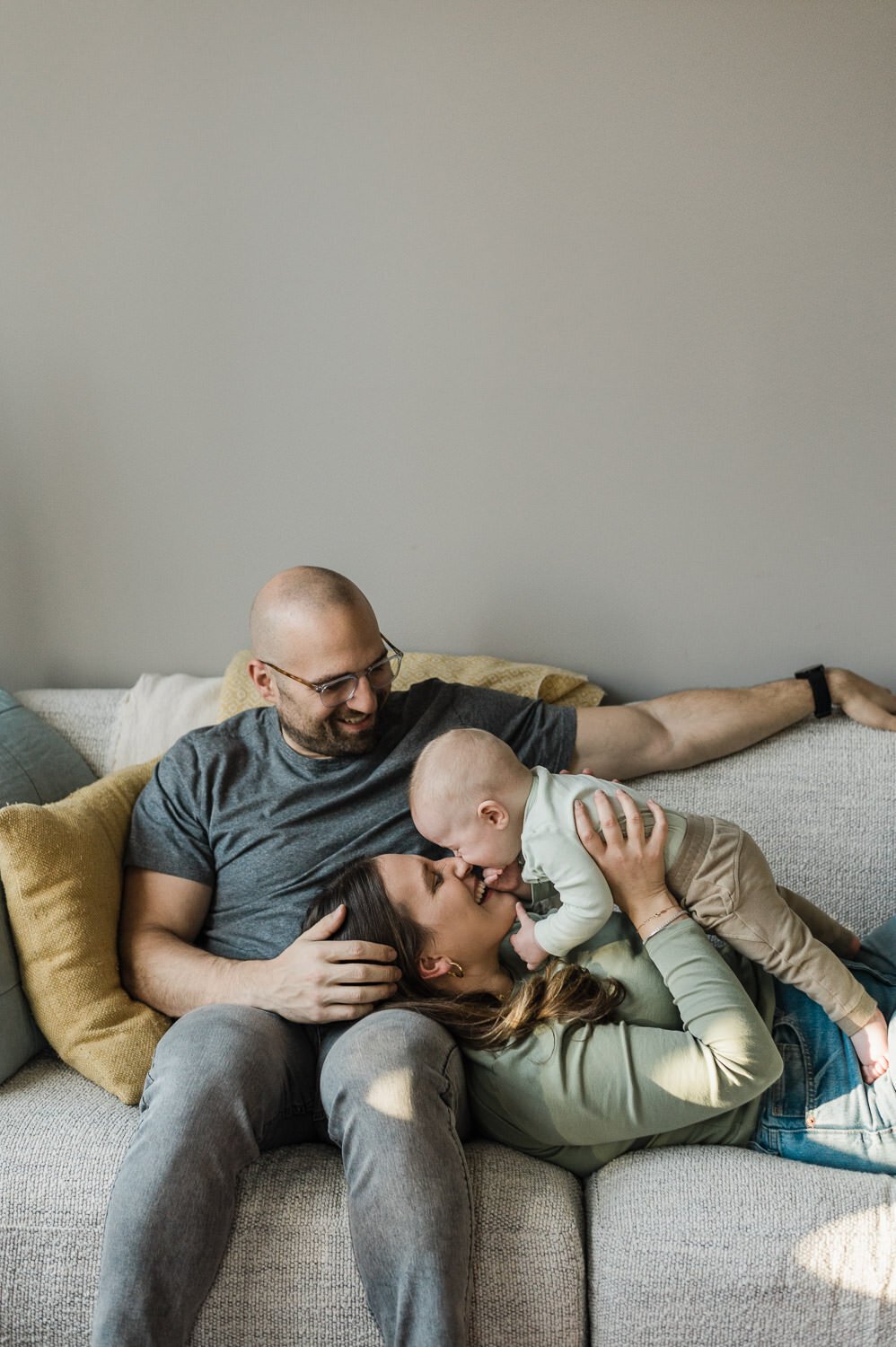 Couple on the couch with baby during Family Portrait Photography session with Rachael Shrum.