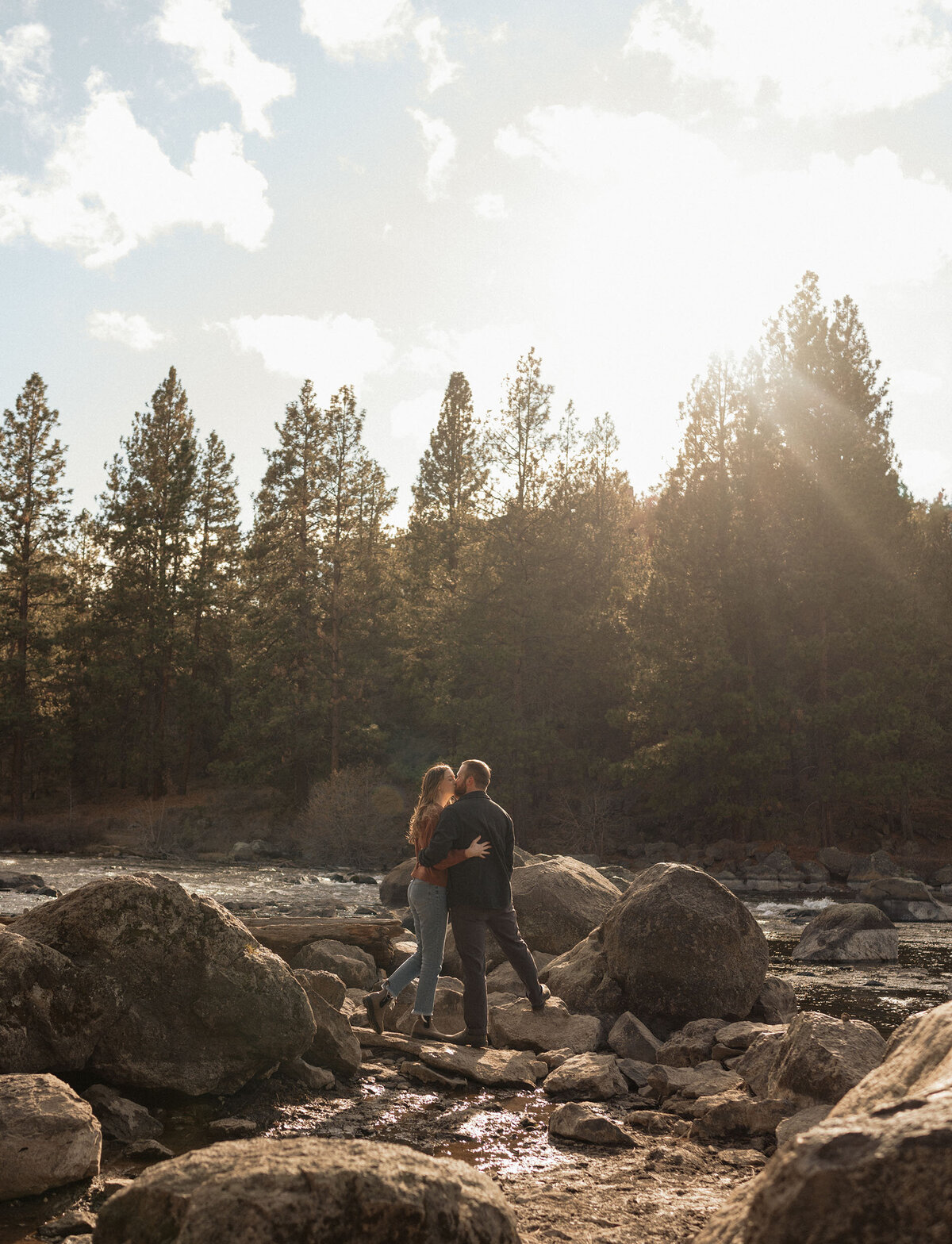 couple embracing and kissing near the river in Bend, Oregon