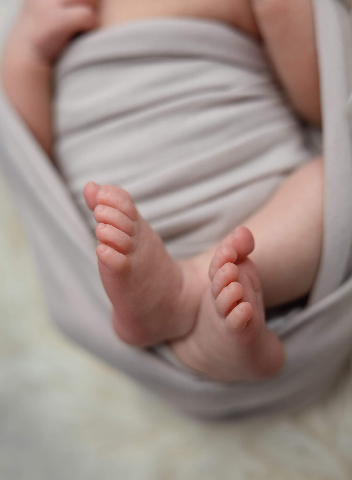 close up of newborn feet while swaddled during newborn session in texas