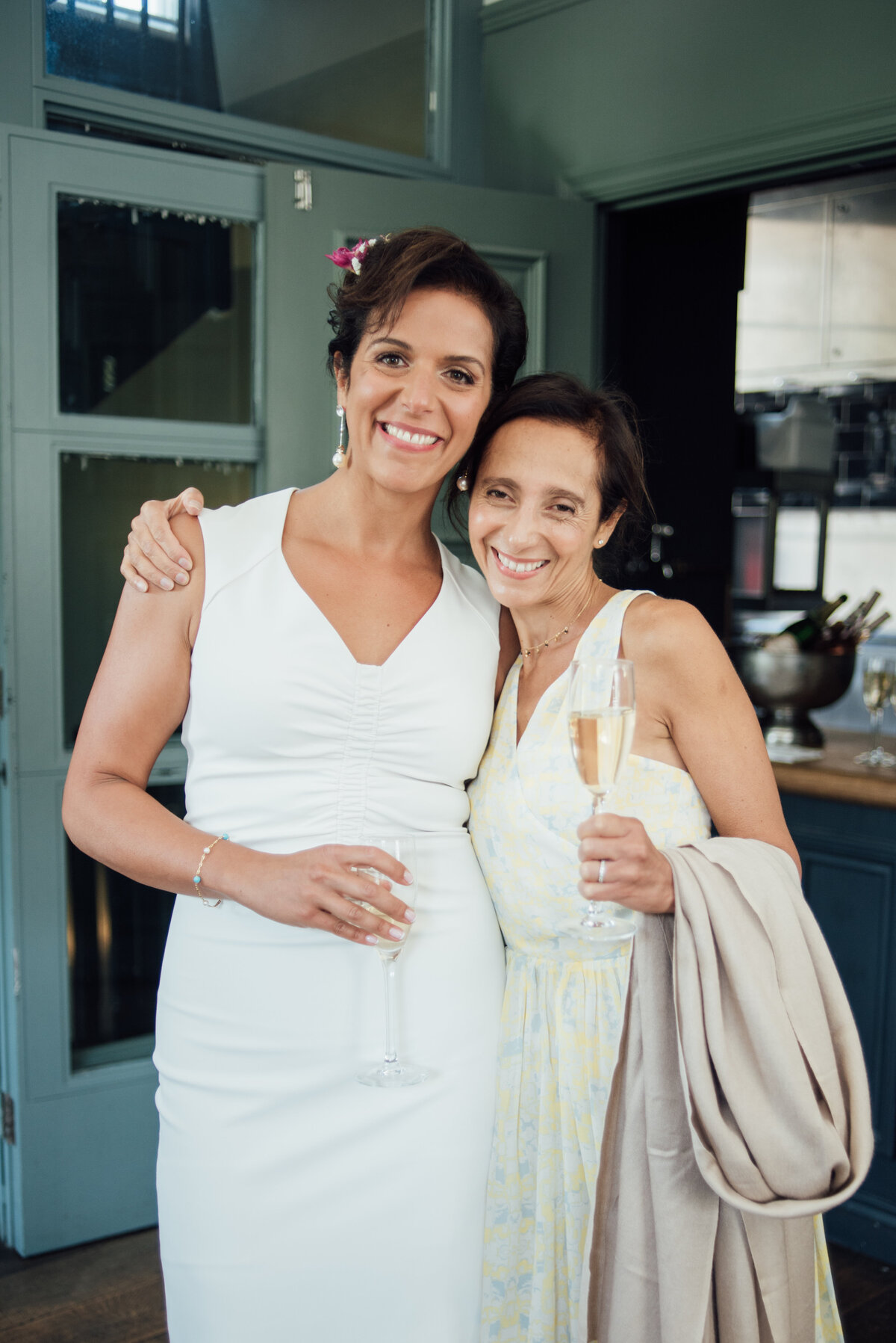 A bride and a family member holding a glass of champagne taken by London Wedding Photographer Liberty Pearl