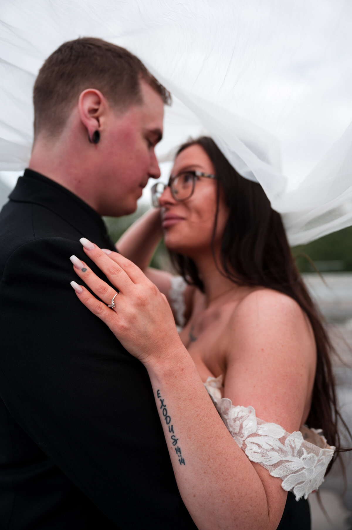 wedding couple looking at each other romantically under the wedding veil 