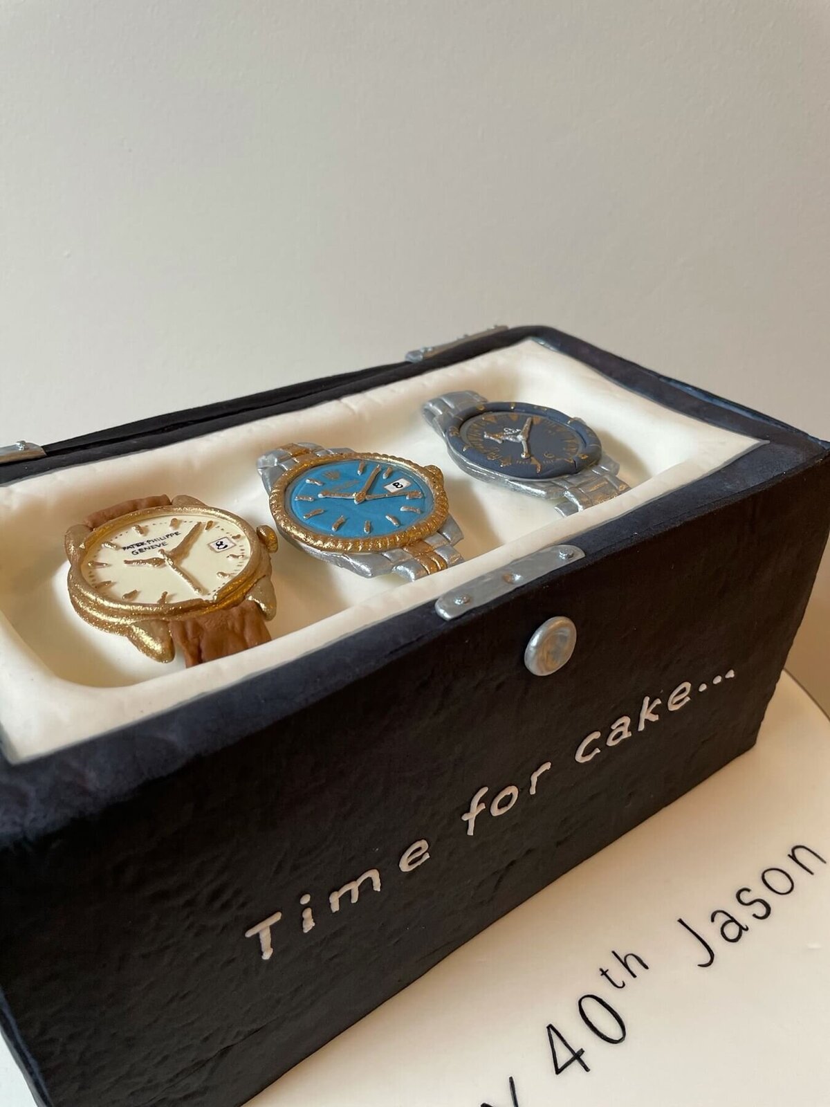 A cake in the shape of a box of three luxury watches