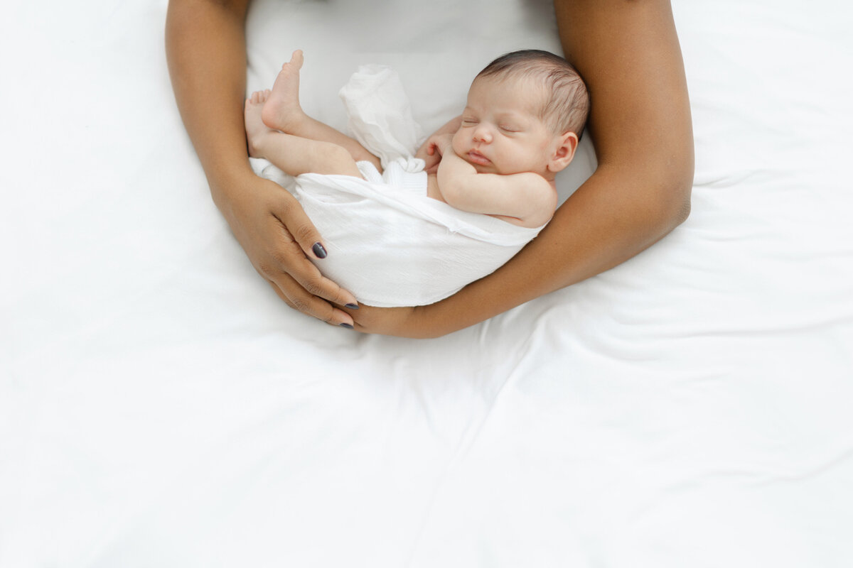 Mother holds sleeping newborn baby