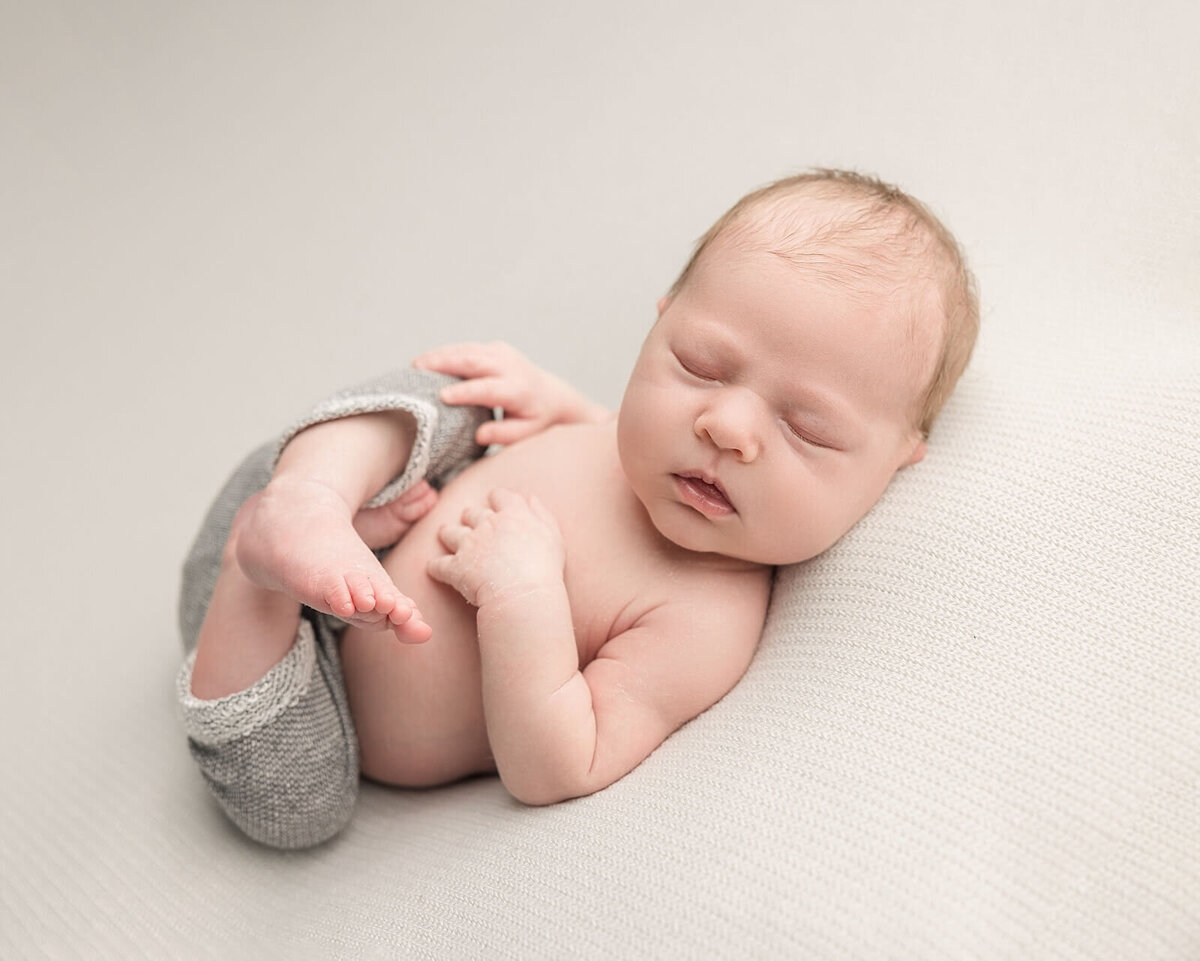 baby boy in grey pants for newborn pictures near portland