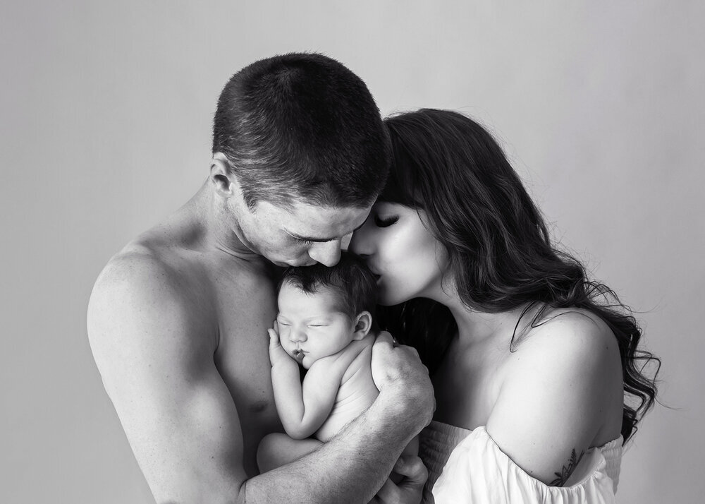 NEWBORN_BABYGIRLWITHPARENTSKISSBLACKANDWHITE