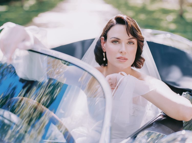 Editorial bride in a vintage convertible, wearing a veil