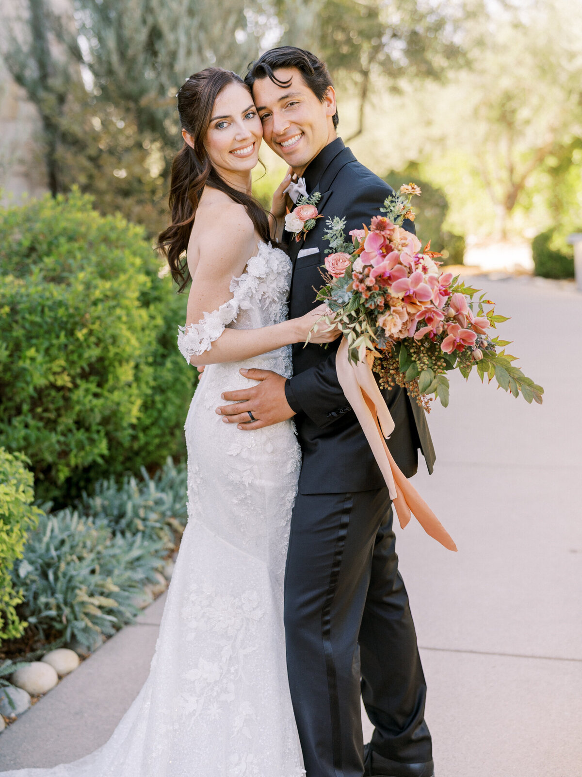Joyful bride and groom share a romantic moment with a lush, cascading bouquet—elegant vineyard wedding vibes.