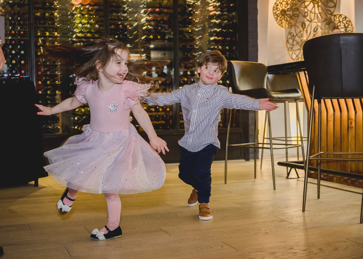 Candid photo of young kids dancing at a fun-filled birthday party.