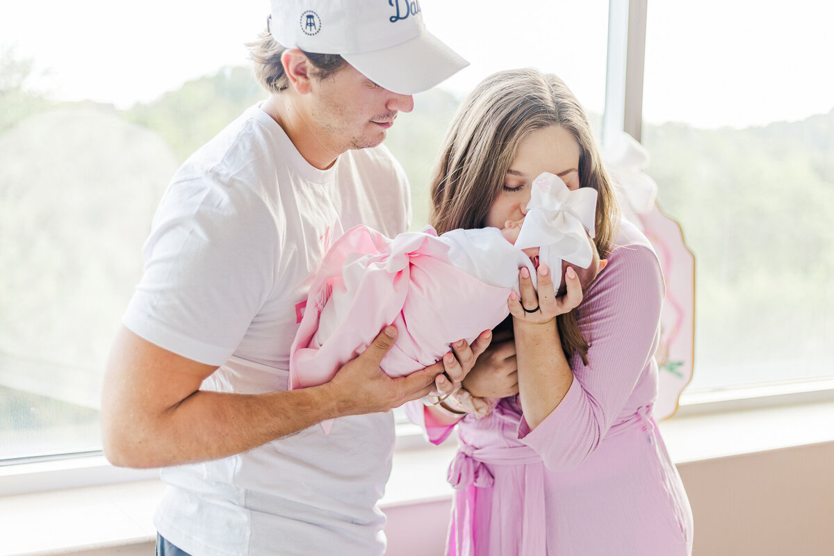 Family gathered around a newborn in the hospital, smiling and sharing joyful moments during fresh-48 photo session at Grandview medical center in Birmingham alabama