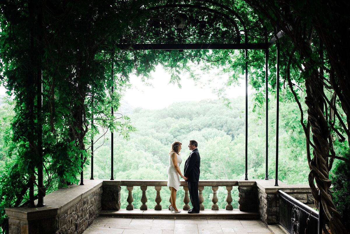 Couple facing one another and holding hands under Cheekwood arbor
