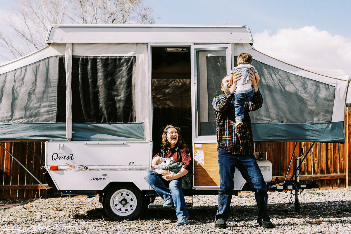family plays in front of camper in loveland colorado