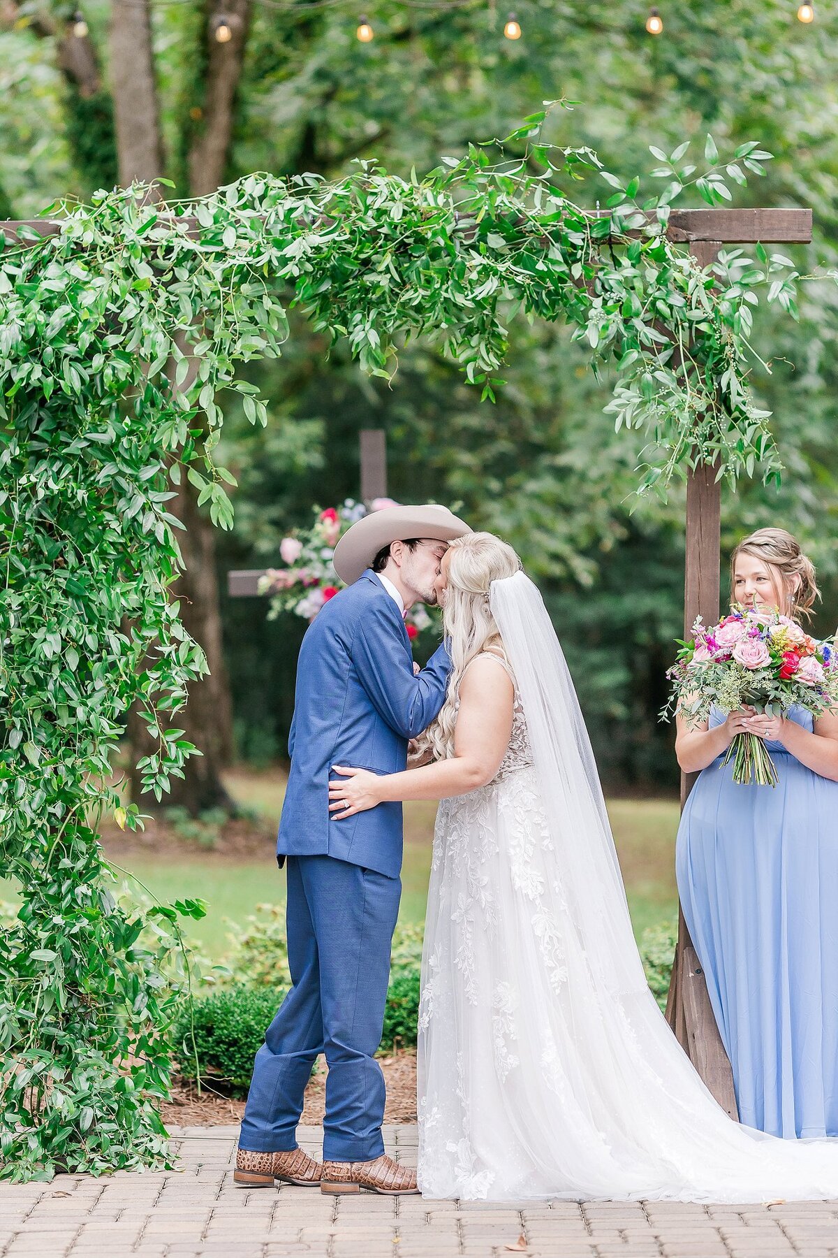 Bride and groom share first kiss at Elms of Coosada wedding ceremony | Wedding Photography by Amanda Horne