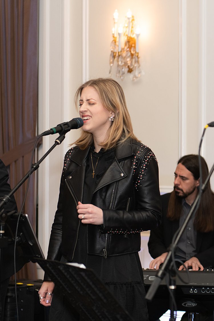 Girl in black studded leather jacket singing during a wedding at University Club in Pittsburgh, PA