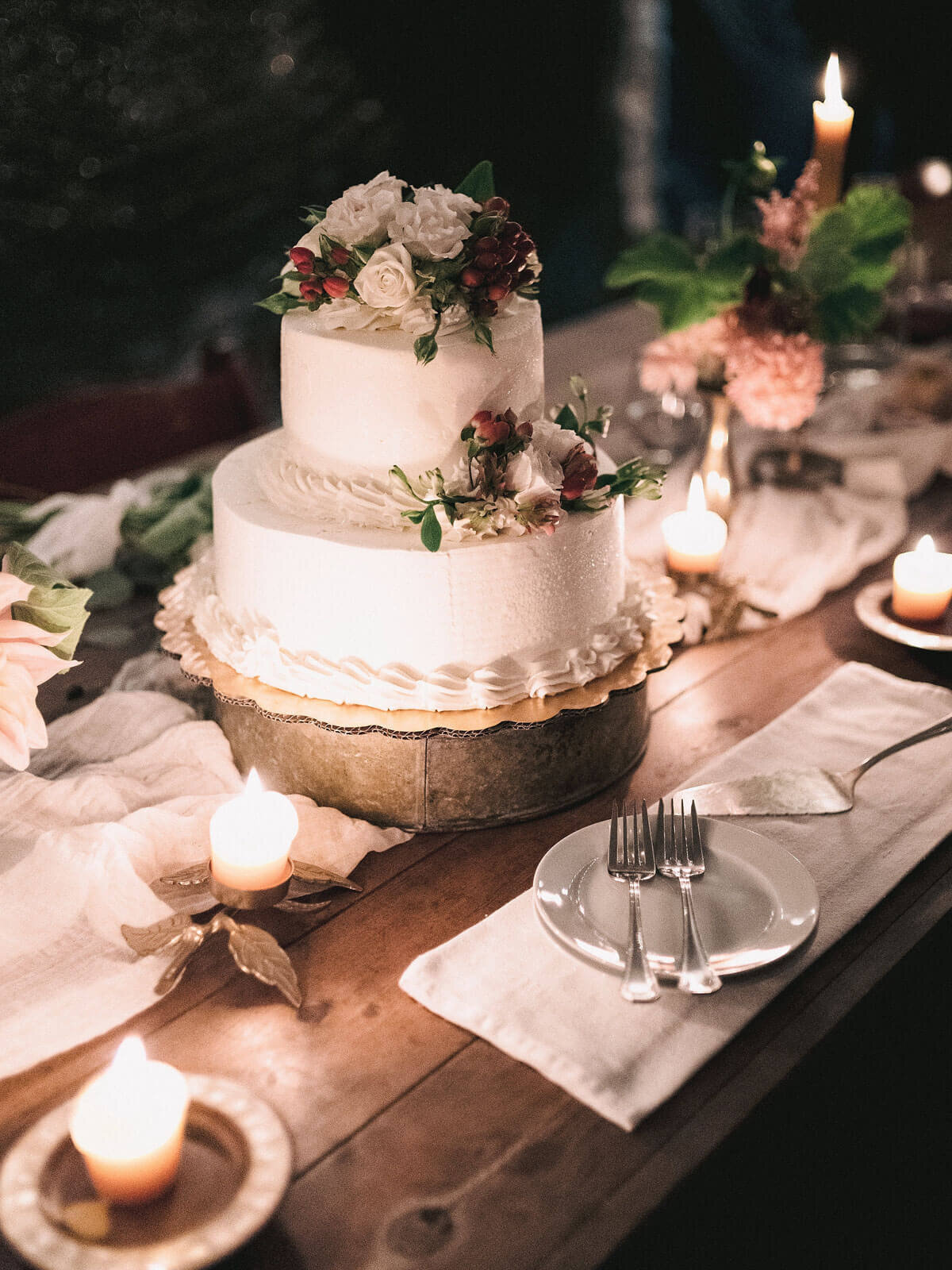 A simple, but beautiful white wedding cake with flowers in Foxfire Mountain House, New York. Wedding Image by Jenny Fu Studio