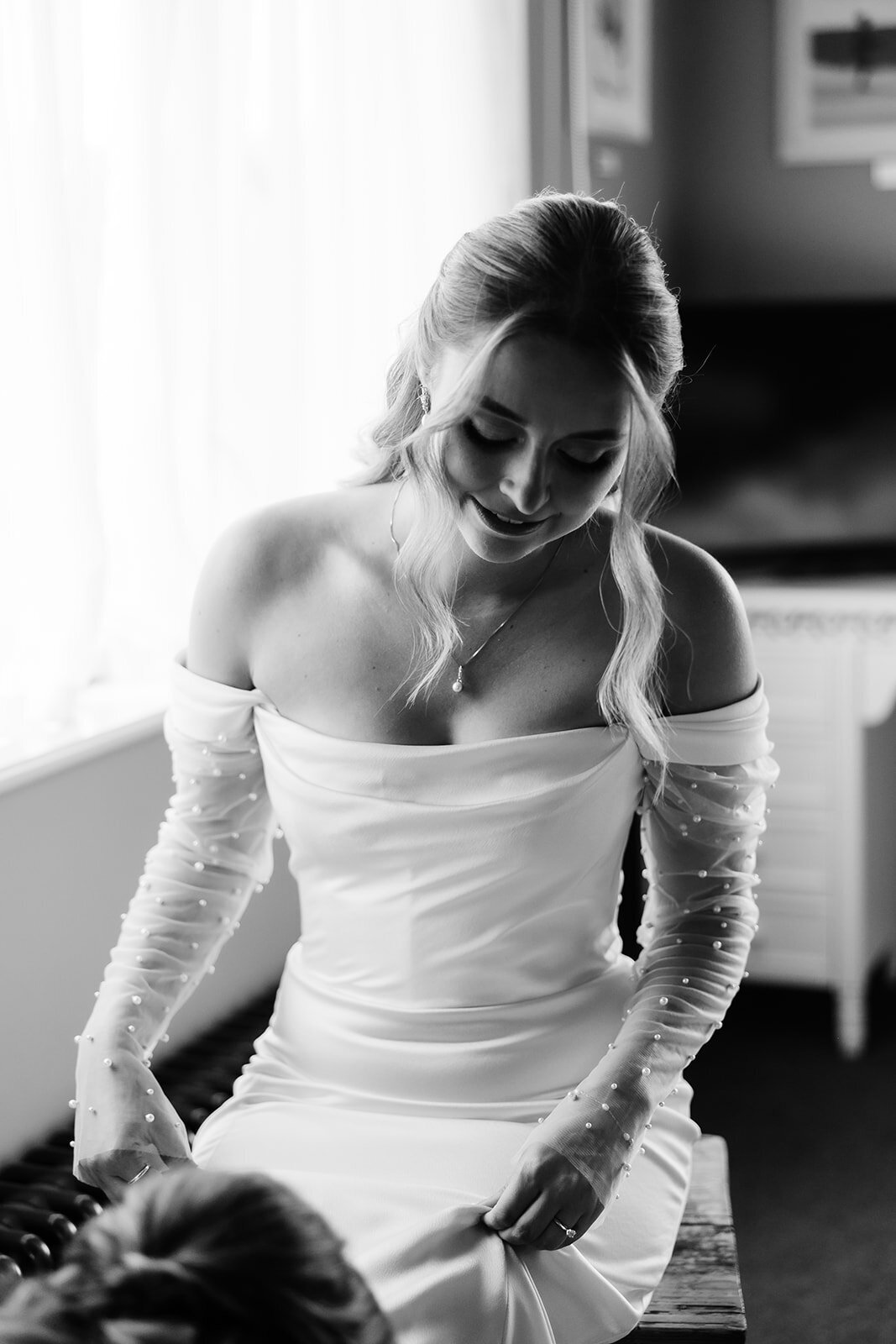 Bride wearing fitted off the sleeve silk wedding dress