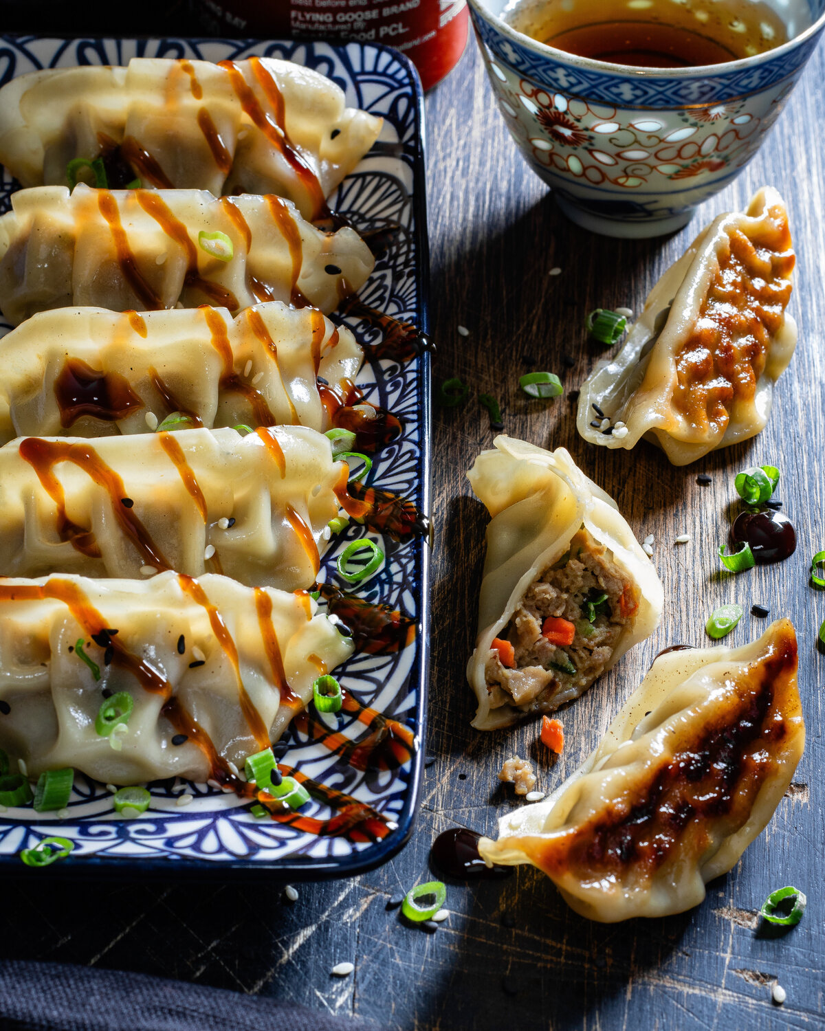 Duck gyoza on a plate with hoisin sauce drizzled over