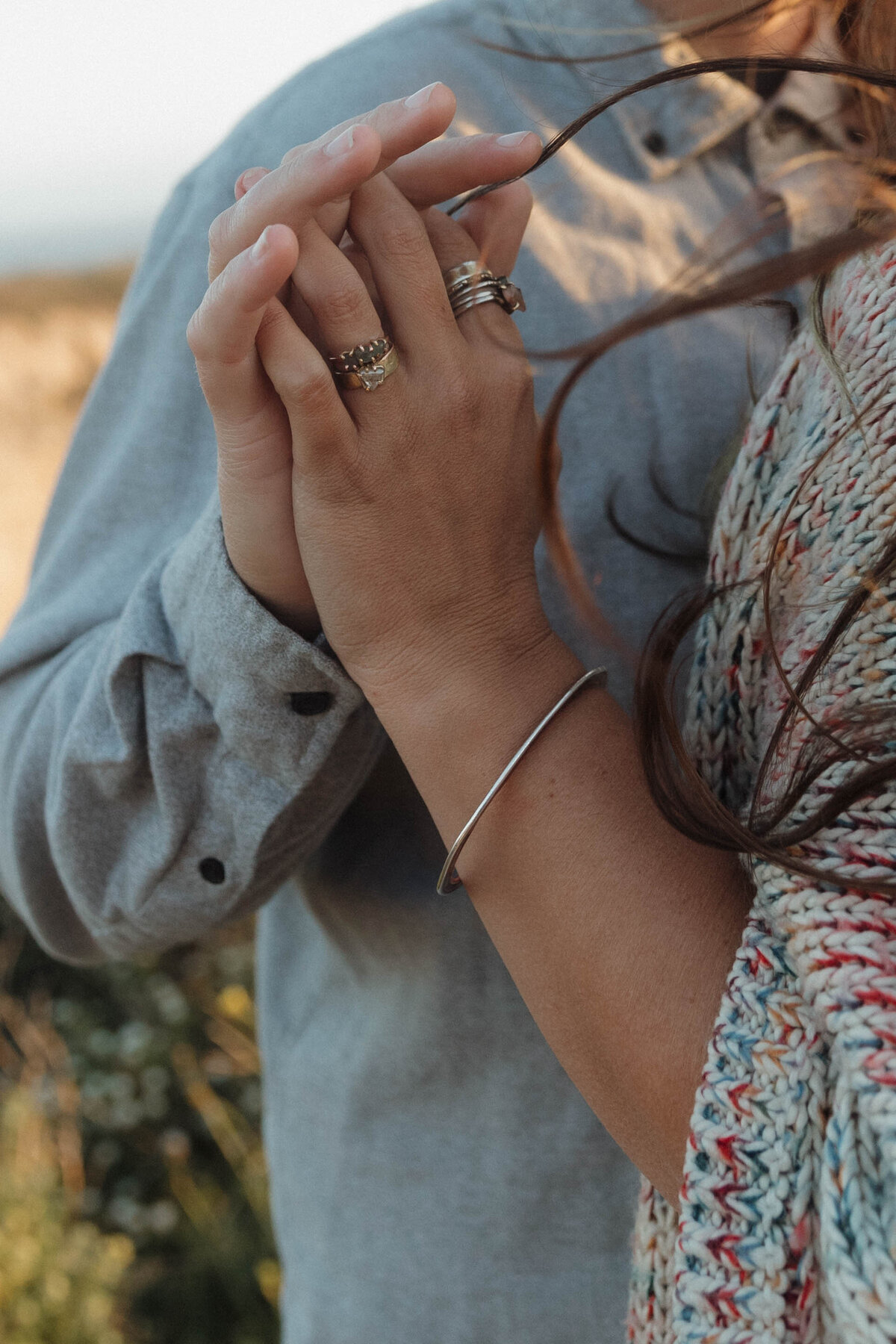 A close-up of a couple holding hands, capturing the emotion and connection in a cinematic engagement photography style.