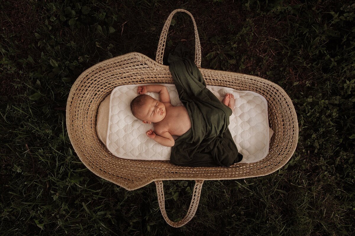 Newborn baby sleeping in a basket during photography session