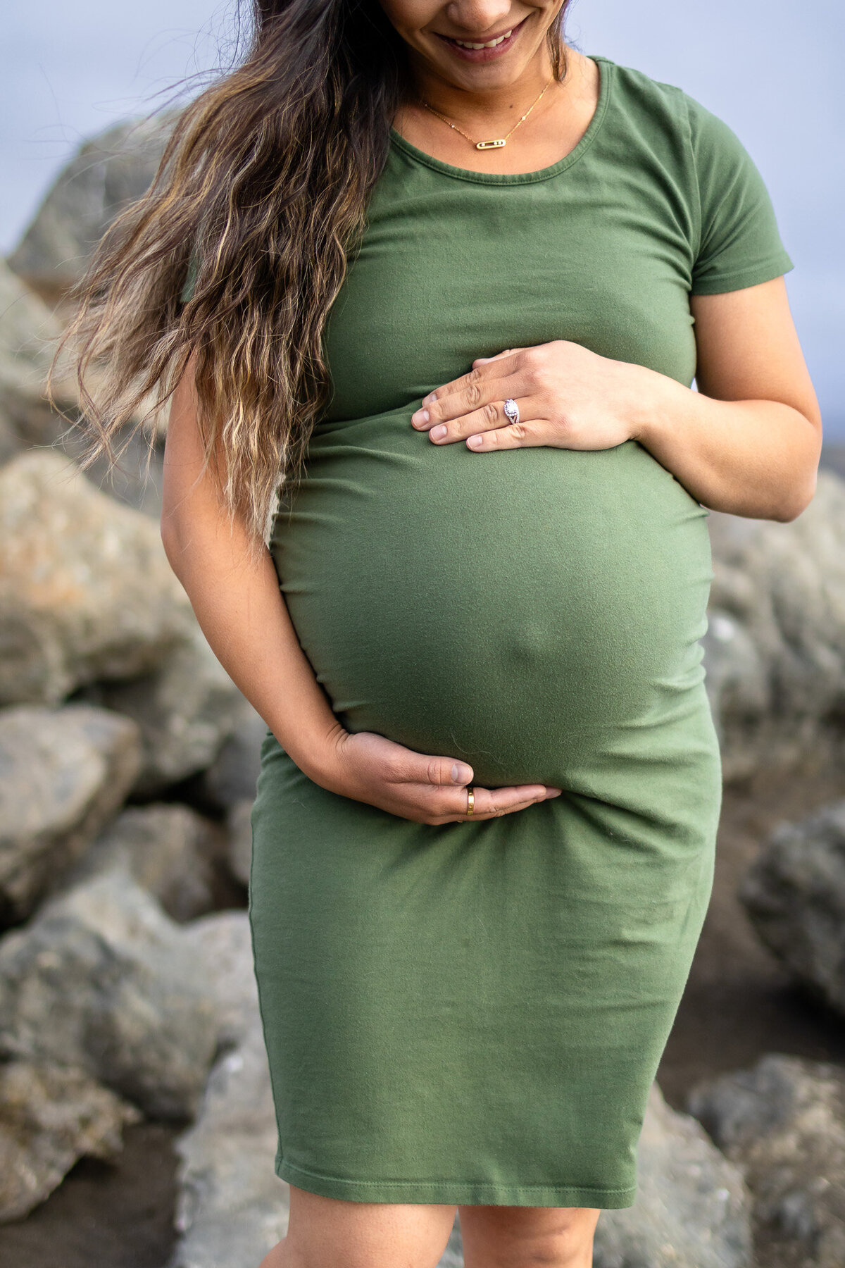 Close-up of a pregnant belly with hands gently cradling the bump, captured for Bay Area Maternity Portfolio - Ellobelle Photography