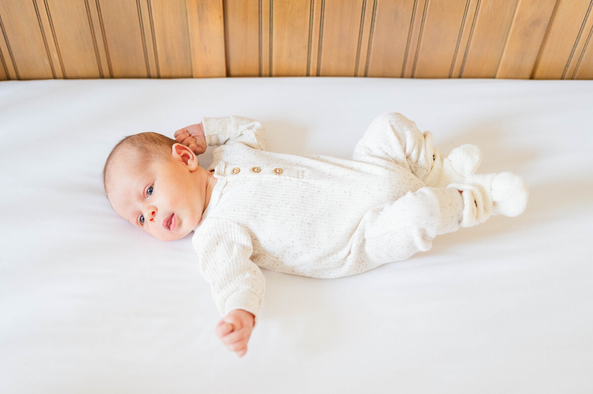 Newborn laying in crib taken in Sutton, MA 