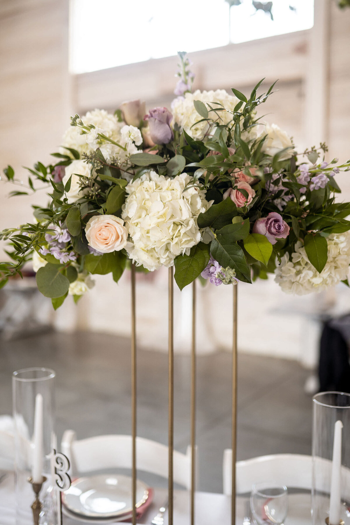 Large gold stand wedding arrangement with white, pink, lavender, and green flowers